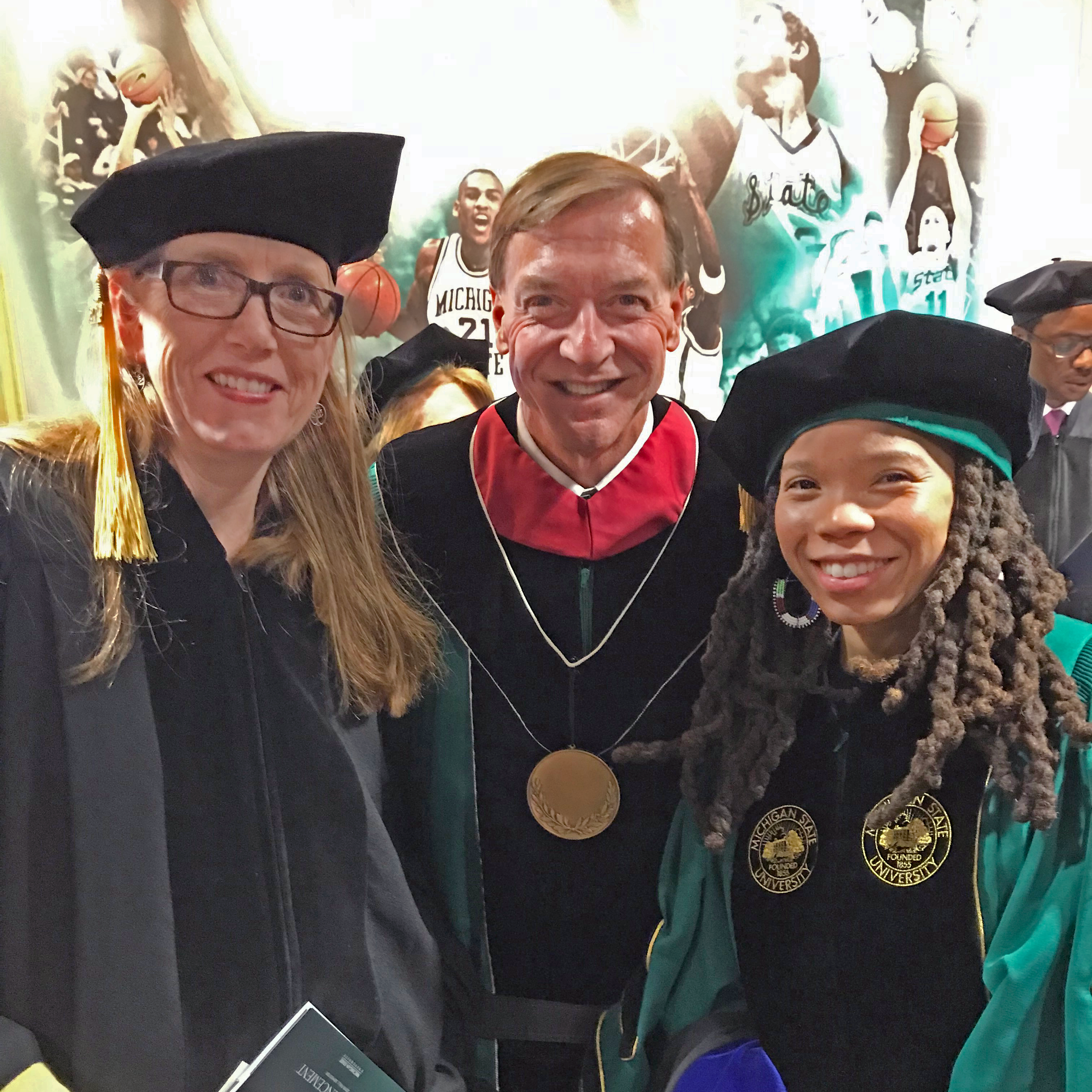 两名科罗拉多州立大学的研究生与斯坦利校长在密歇根州立大学高级学位毕业典礼上