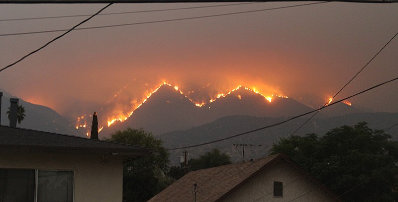远处山上的火，前景是房子。