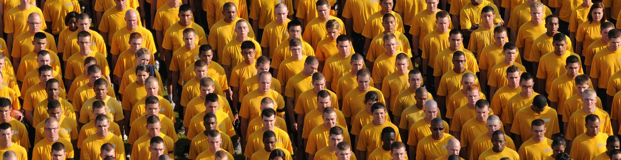 一群穿着黄色衬衫的男人和女人肩并肩站成一排。